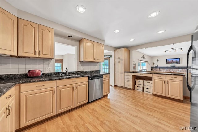 kitchen featuring dishwasher, a sink, light brown cabinets, light wood-style flooring, and tasteful backsplash
