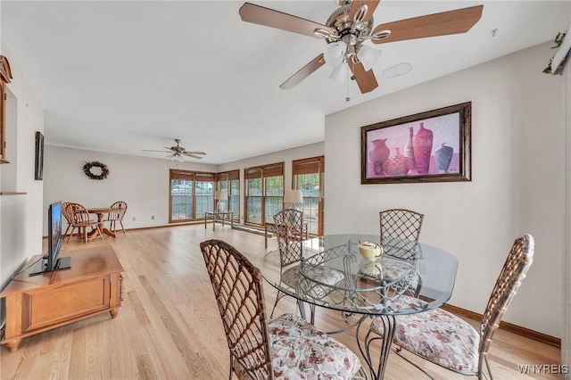 dining space with a ceiling fan, light wood-style floors, and baseboards