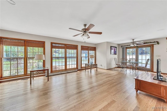 unfurnished living room featuring ceiling fan and light wood-type flooring