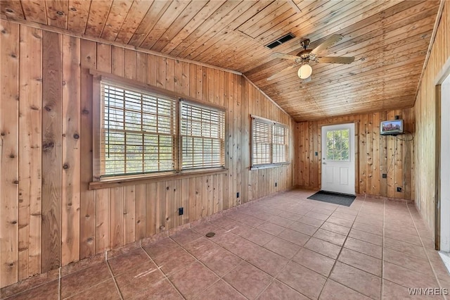 spare room featuring wooden ceiling, wooden walls, vaulted ceiling, a ceiling fan, and tile patterned flooring