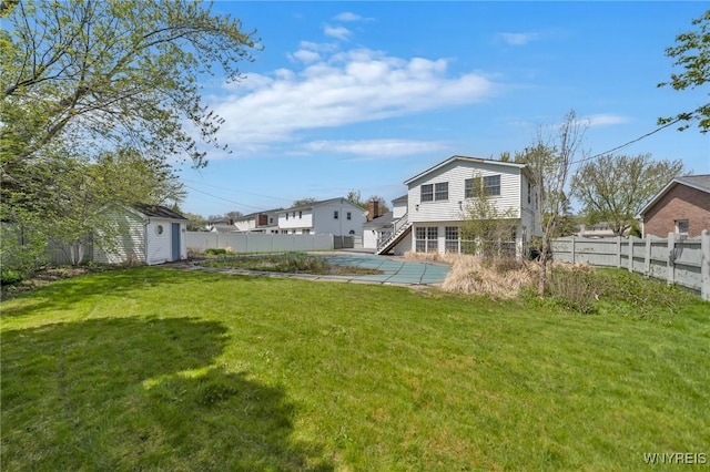 view of yard featuring a pool, stairway, and an outdoor structure