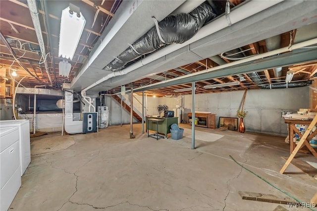 unfinished basement with gas water heater, washer and dryer, and heating unit