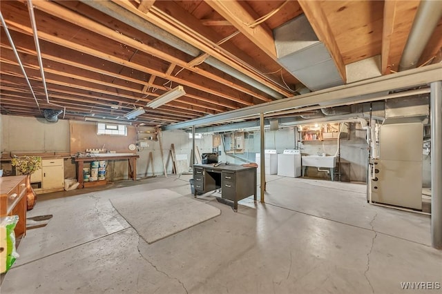 below grade area with independent washer and dryer, a sink, and a workshop area