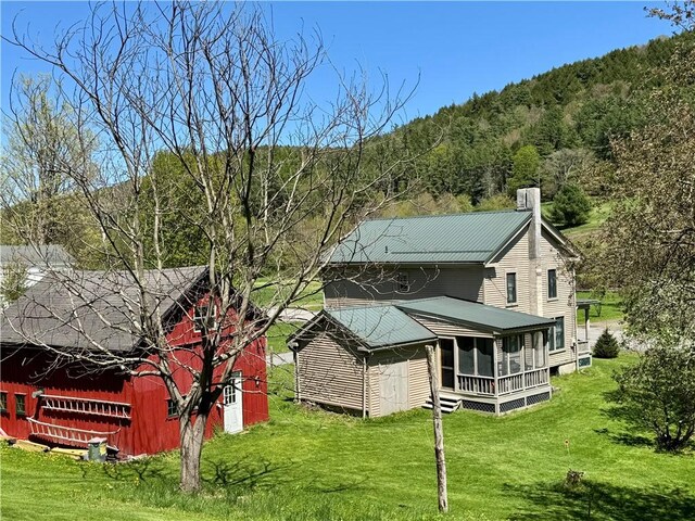2395 State Highway 205, Laurens, NY 13810 - rear view of house featuring a chimney, a yard, an outdoor structure, and a wooded view