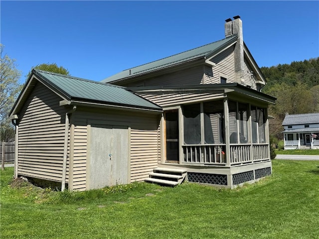 2395 State Highway 205, Laurens, NY 13810 - rear view of property featuring a sunroom, a yard, metal roof, and a chimney