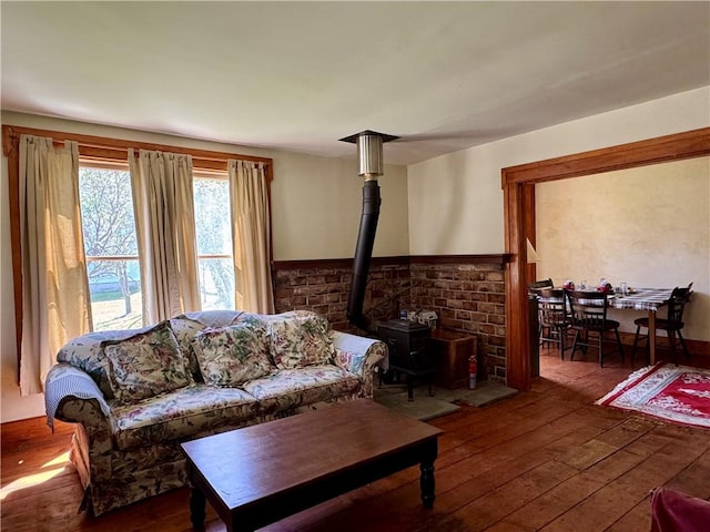 2395 State Highway 205, Laurens, NY 13810 - living area featuring hardwood / wood-style floors, a wood stove, and a wainscoted wall