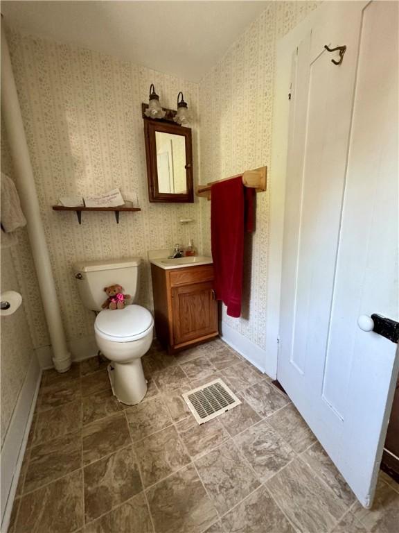 2395 State Highway 205, Laurens, NY 13810 - bathroom featuring wallpapered walls, toilet, and vanity