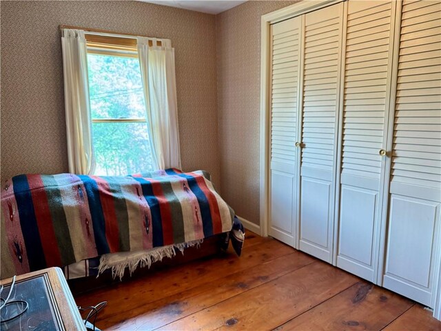 2395 State Highway 205, Laurens, NY 13810 - bedroom featuring hardwood / wood-style floors, a closet, and wallpapered walls