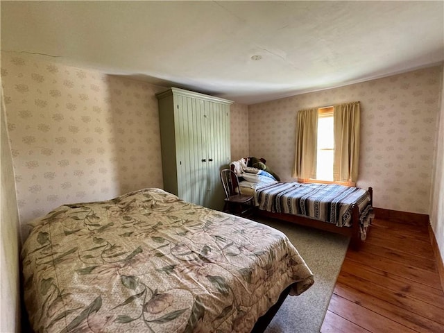 2395 State Highway 205, Laurens, NY 13810 - bedroom featuring wood-type flooring, wallpapered walls, and baseboards