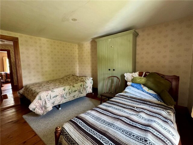 2395 State Highway 205, Laurens, NY 13810 - bedroom featuring wood finished floors and wallpapered walls