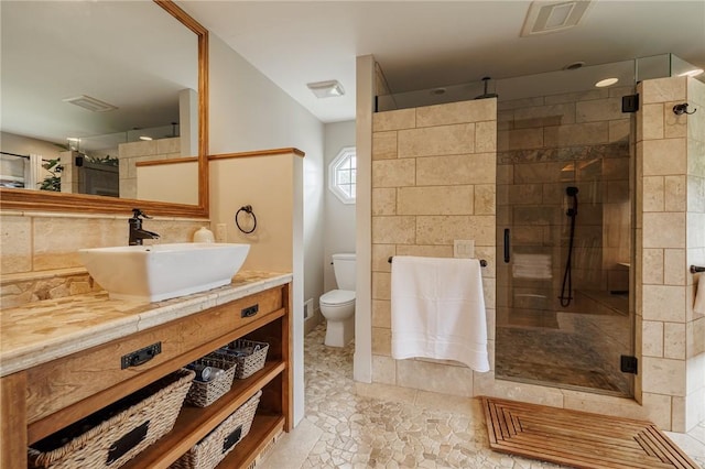 full bathroom with a shower stall, vanity, toilet, backsplash, and tile patterned flooring