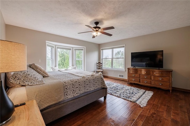 bedroom with wood finished floors, baseboards, a ceiling fan, and a textured ceiling