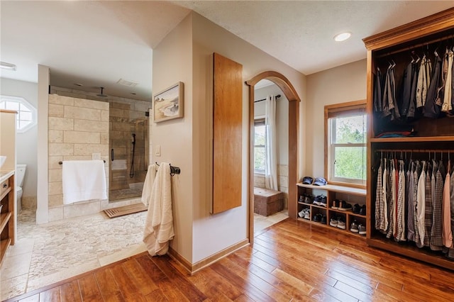 bathroom with wood-type flooring, a stall shower, baseboards, and vanity