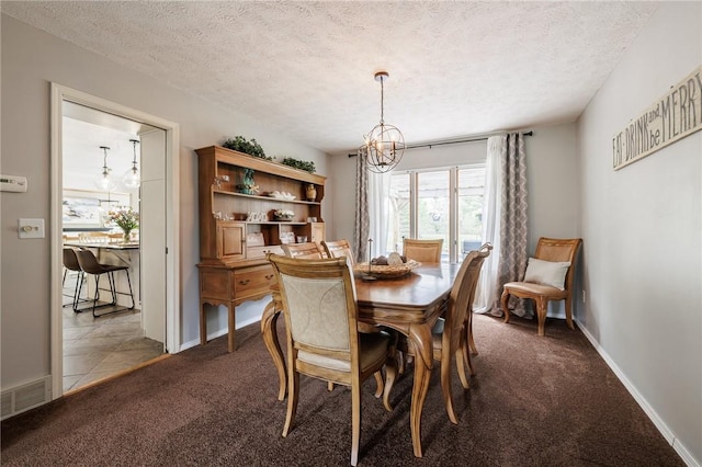 carpeted dining space featuring a chandelier, a textured ceiling, and baseboards