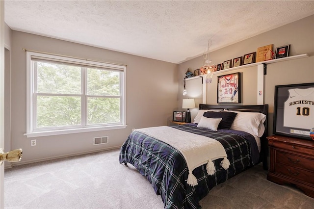 carpeted bedroom with a textured ceiling and baseboards