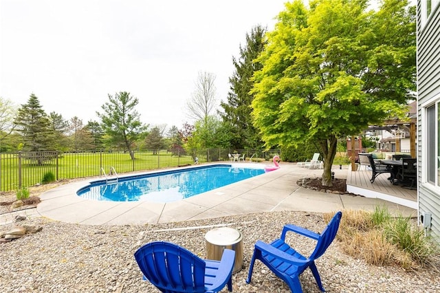view of swimming pool featuring a fenced backyard, a patio, and view of wooded area
