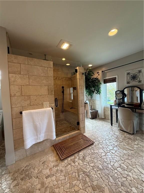 bathroom featuring stone finish flooring, a shower stall, and recessed lighting