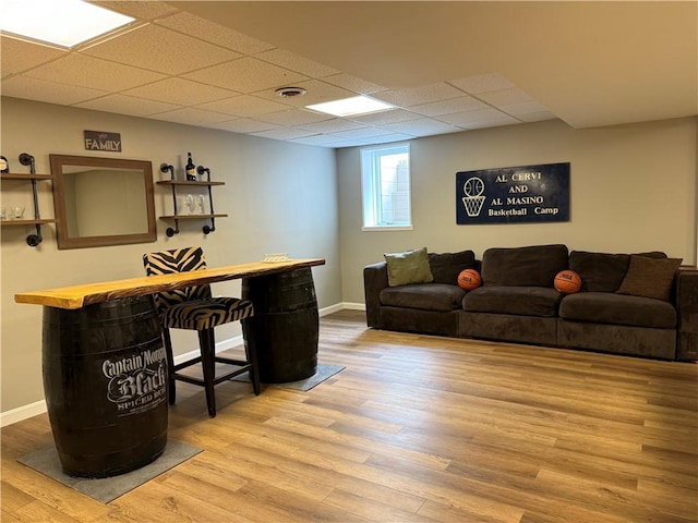 office area featuring wood finished floors, a drop ceiling, and baseboards