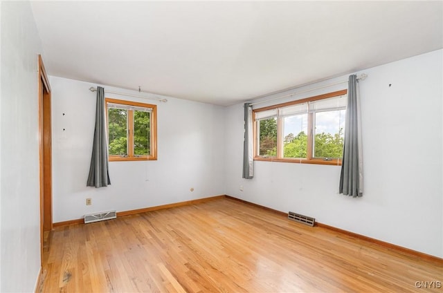spare room featuring light wood-style flooring and baseboards