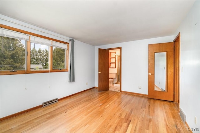 empty room featuring light wood-type flooring and baseboards