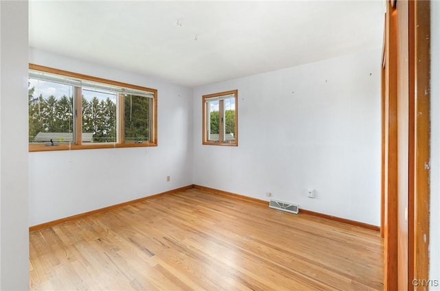 empty room featuring baseboards and light wood finished floors