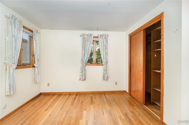 unfurnished bedroom featuring light wood-style flooring and baseboards