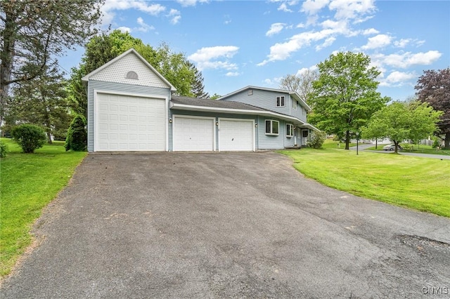 view of front facade featuring a garage, driveway, a front yard, and a shingled roof