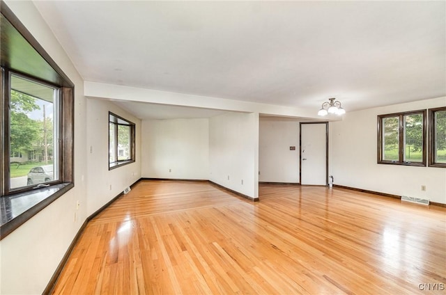 spare room featuring light wood-type flooring and baseboards