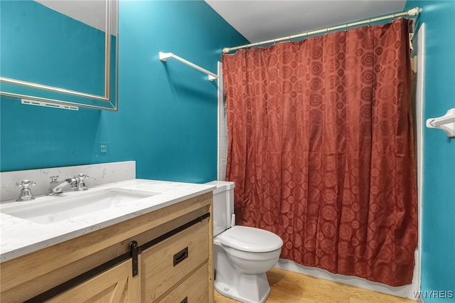 full bath featuring toilet, vanity, curtained shower, and wood finished floors