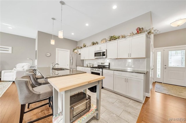6811 Rivera Way, Clarence, NY 14051 - kitchen with appliances with stainless steel finishes, a sink, backsplash, white cabinets, and decorative light fixtures