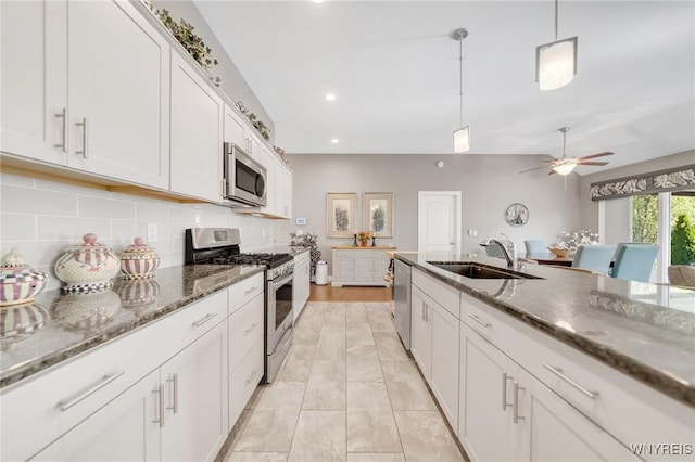 6811 Rivera Way, Clarence, NY 14051 - kitchen featuring appliances with stainless steel finishes, a sink, backsplash, a ceiling fan, and white cabinetry