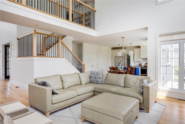 313 Wexford Ln, Horseheads, NY 14845 - living area with a towering ceiling, light wood finished floors, stairs, plenty of natural light, and baseboards
