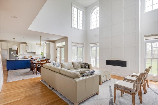 313 Wexford Ln, Horseheads, NY 14845 - living area with a fireplace, light wood-style flooring, and a high ceiling