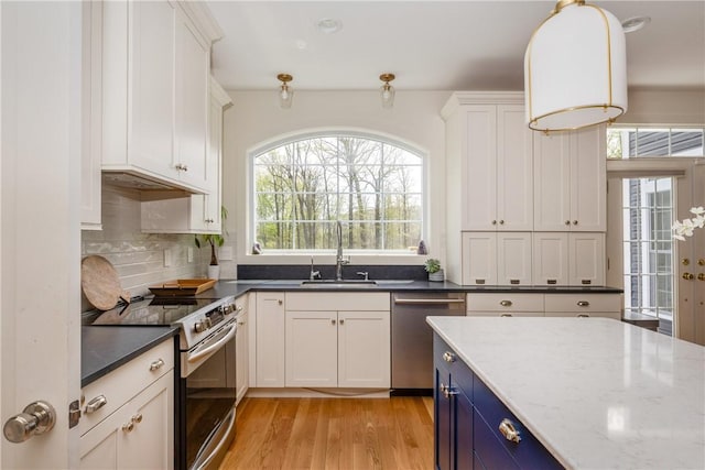 313 Wexford Ln, Horseheads, NY 14845 - kitchen with stainless steel appliances, a sink, blue cabinetry, light wood finished floors, and white cabinetry