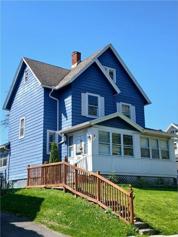 view of front of house featuring a chimney and a front lawn