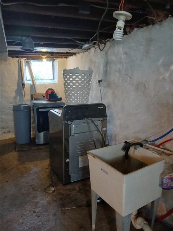 below grade area featuring washing machine and clothes dryer and a sink