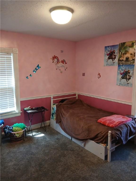 carpeted bedroom featuring a textured ceiling