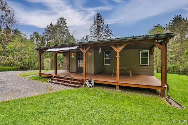 back of property featuring a yard and metal roof