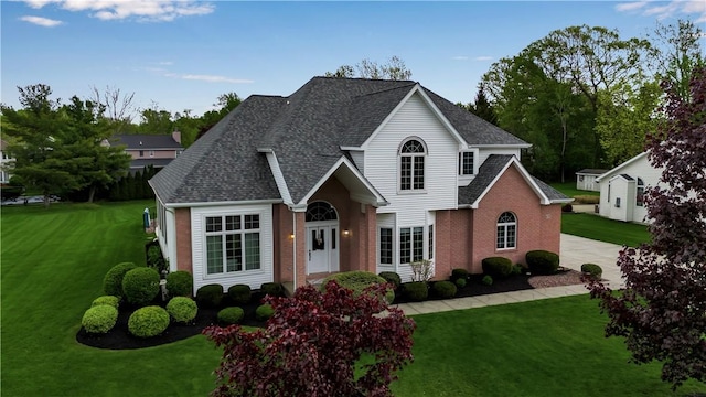 670 Raymond Dr, Lewiston, NY 14092 - traditional-style house with a front lawn, brick siding, a shingled roof, and driveway