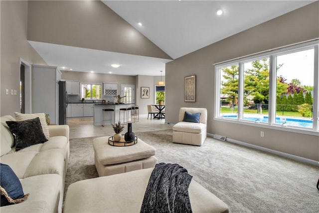 670 Raymond Dr, Lewiston, NY 14092 - living area featuring baseboards, recessed lighting, light colored carpet, and high vaulted ceiling