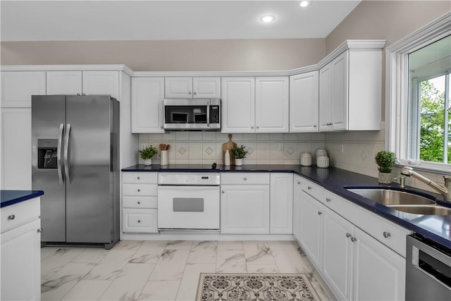 670 Raymond Dr, Lewiston, NY 14092 - kitchen featuring appliances with stainless steel finishes, a sink, light marble finish flooring, white cabinetry, and recessed lighting