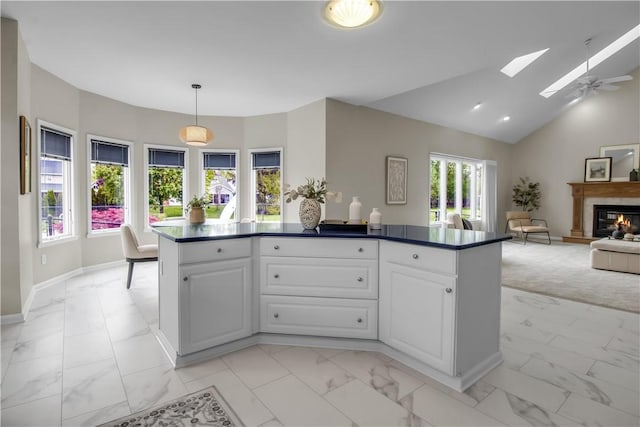670 Raymond Dr, Lewiston, NY 14092 - kitchen with light marble finish flooring, dark countertops, white cabinetry, open floor plan, and lofted ceiling