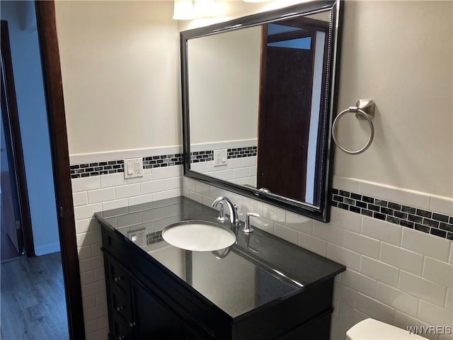 5854 Main St Unit 407, Amherst, NY 14221 - half bath featuring tile walls, vanity, a wainscoted wall, and wood finished floors