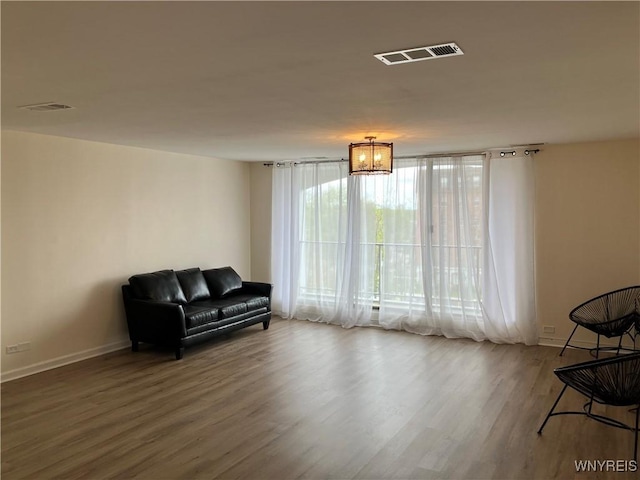 5854 Main St Unit 407, Amherst, NY 14221 - living area featuring wood finished floors, baseboards, and a chandelier