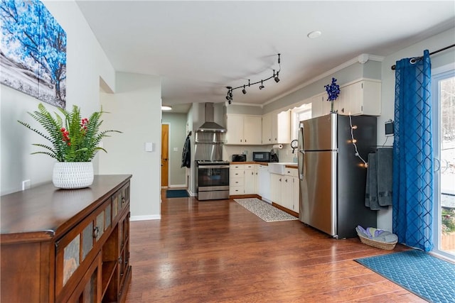 kitchen featuring stainless steel appliances, wall chimney exhaust hood, dark wood finished floors, and white cabinets