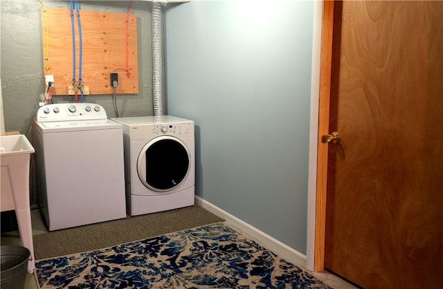 washroom with washer and dryer and baseboards