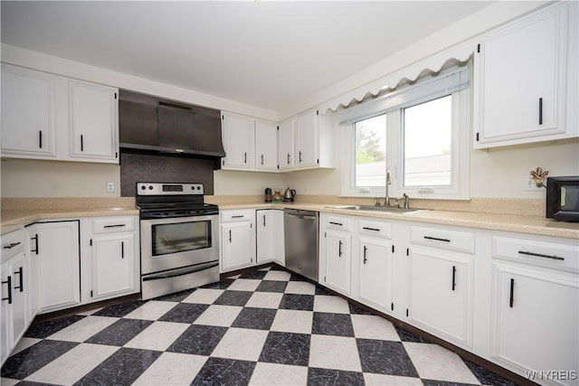 kitchen featuring appliances with stainless steel finishes, a sink, exhaust hood, dark flooring, and white cabinetry