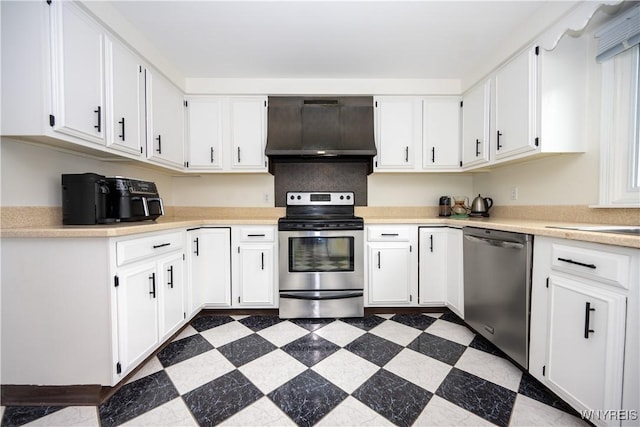 kitchen with ventilation hood, appliances with stainless steel finishes, light countertops, and white cabinets
