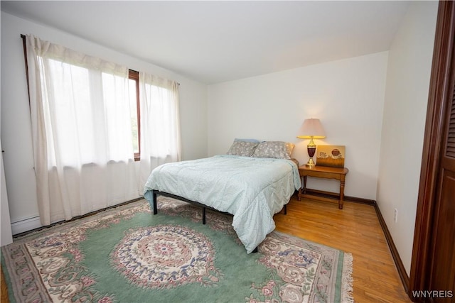 bedroom with light wood-type flooring and baseboards
