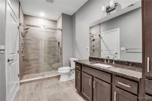 full bath with toilet, a stall shower, and vanity